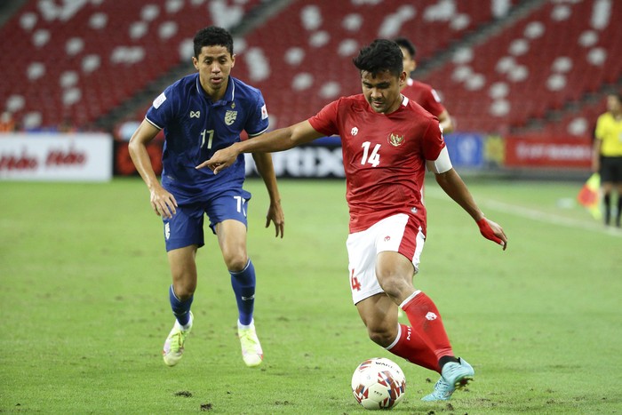 Asnawi Mangkualam of Indonesia, right, controls the ball as Bordin Phala of Thailand looks on during the AFF Suzuki Cup 2020 final first leg soccer match between Indonesia and Thailand in Singapore, Wednesday, Dec. 29, 2021. (AP Photo/Suhaimi Abdullah)