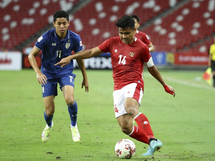 Asnawi Mangkualam of Indonesia, right, controls the ball as Bordin Phala of Thailand looks on during the AFF Suzuki Cup 2020 final first leg soccer match between Indonesia and Thailand in Singapore, Wednesday, Dec. 29, 2021. (AP Photo/Suhaimi Abdullah)