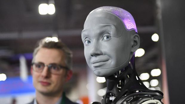 Morgan Roe, director of operations at Engineered Arts, speaks about the Engineered Arts Ameca humanoid robot with artificial intelligence as it is demonstrated during the Consumer Electronics Show (CES) on January 5, 2022 in Las Vegas, Nevada. (Photo by Patrick T. FALLON / AFP)