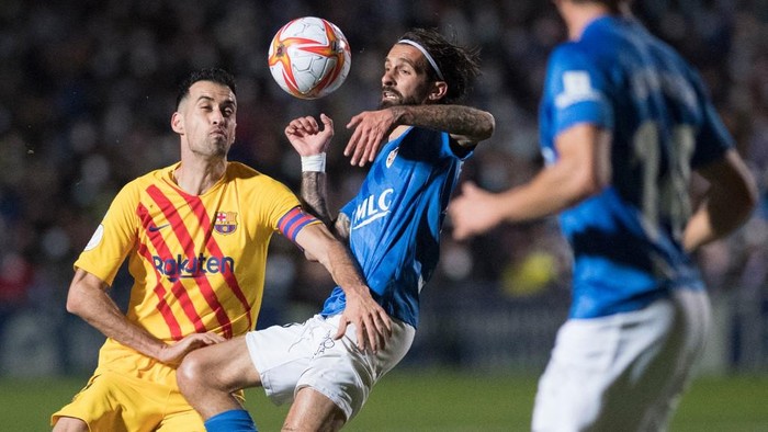 Barcelonas Spanish midfielder Sergio Busquets (L) fights for the ball with Linares Spanish midfielder Fran Carnicer during the Spanish Copa del Rey (Kings Cup) football match between Linares Deportivo and FC Barcelona at the Linarejos stadium in Linares, on January 5, 2022. (Photo by JORGE GUERRERO / AFP)