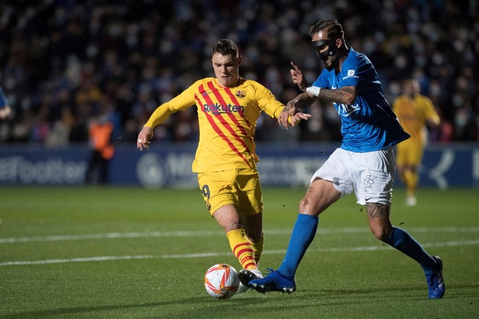 Barcelonas Spanish midfielder Ferran Jutgla (L) fights for the ball with Linares Spanish defender Josema during the Spanish Copa del Rey (Kings Cup) football match between Linares Deportivo and FC Barcelona at the Linarejos stadium in Linares, on January 5, 2022. (Photo by JORGE GUERRERO / AFP)