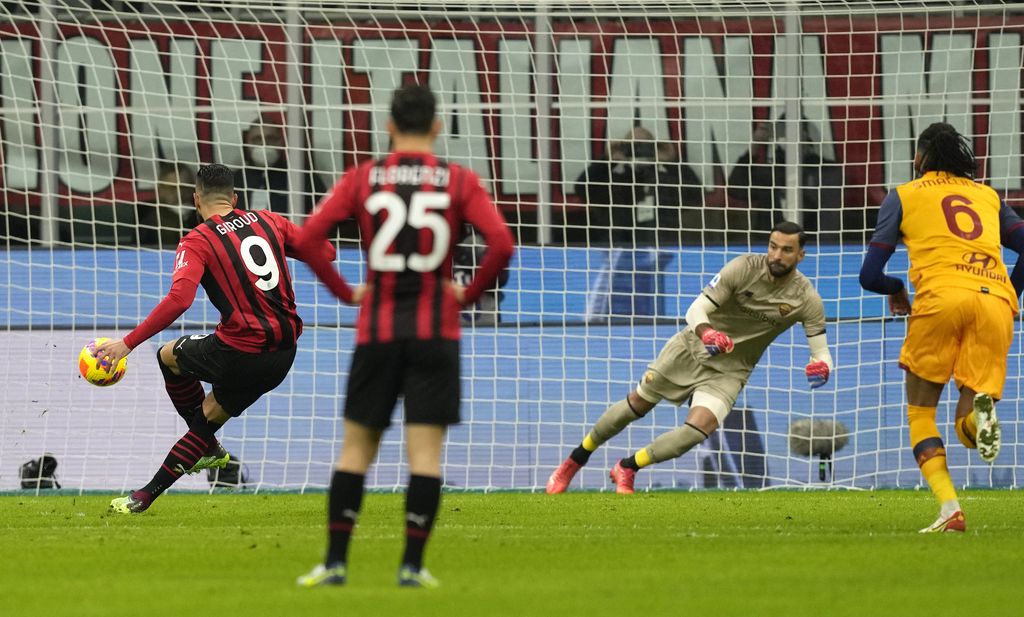 AC Milan's Olivier Giroud, left, scores his side's opening goal during the Serie A soccer match between AC Milan and Roma at the San Siro stadium, in Milan, Italy, Thursday, Jan. 6, 2022. (AP Photo/Antonio Calanni)