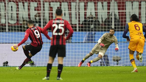 AC Milan's Olivier Giroud, left, scores his side's opening goal during the Serie A soccer match between AC Milan and Roma at the San Siro stadium, in Milan, Italy, Thursday, Jan. 6, 2022. (AP Photo/Antonio Calanni)
