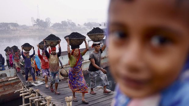 Nyalang Edisi 8 Januari 2022 Workers carry coal as they unload a ferry at Gabtoli in Dhaka, Bangladesh, January 2, 2022. REUTERS/Mohammad Ponir Hossain