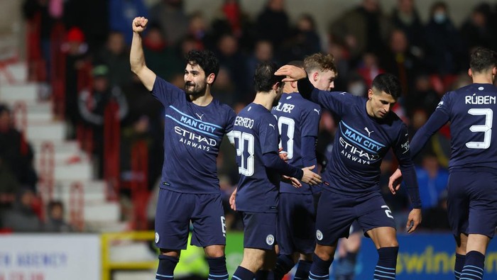 SWINDON, ENGLAND - JANUARY 07: Ilkay Guendogan of Manchester City celebrates with team mates after scoring his sides third goal during the Emirates FA Cup Third Round match between Swindon Town and Manchester City at County Ground on January 07, 2022 in Swindon, England. (Photo by Catherine Ivill/Getty Images)