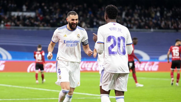 MADRID, SPAIN - JANUARY 08: Vinicius Jr of Real Madrid CF celebrates with his team mate Karim Benzema after scoring his teams second goal during the La Liga Santader match between Real Madrid CF and Valencia CF at Estadio Santiago Bernabeu on January 8, 2022 in Madrid, Spain. (Photo by Gonzalo Arroyo Moreno/Getty Images)
