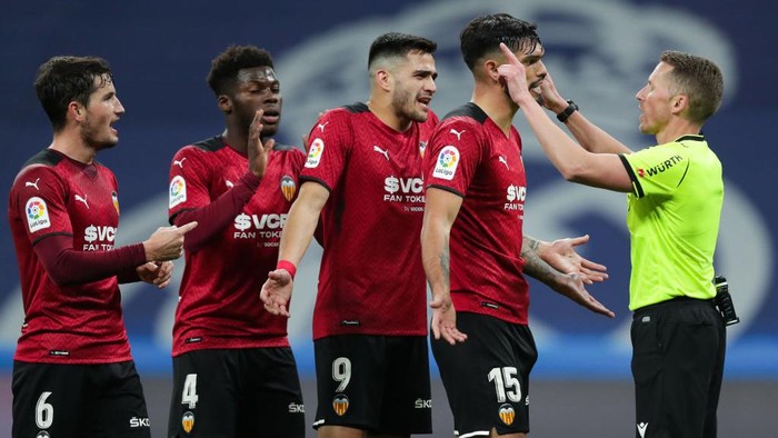 MADRID, SPAIN - JANUARY 08: (L-R) Hugo Guilamon, Yunus Musah, Maxi Gomez and Omar Alderete of Valencia CF argue with the referee Alejandro Hernandez Hernandez during the La Liga Santader match between Real Madrid CF and Valencia CF at Estadio Santiago Bernabeu on January 8, 2022 in Madrid, Spain. (Photo by Gonzalo Arroyo Moreno/Getty Images)