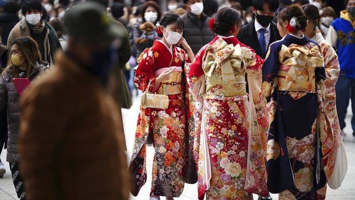 Kimono-clad women celebrating turning 20 years old take selfie together prior to attending a Coming-of-Age ceremony Monday, Jan. 10, 2022, in Tokyo. Held annually on the second Monday of January, Coming of Age Day is a special time for those young adults. (AP Photo/Eugene Hoshiko)