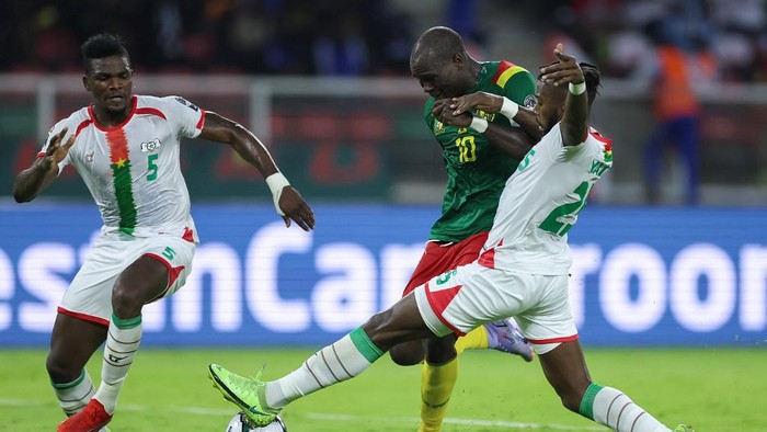 Cameroons forward Vincent Aboubakar (C) is tackled by Burkina Fasos defender Steeve Yago (R) during the Group A Africa Cup of Nations (CAN) 2021 football match between Cameroon and Burkina Faso at Stade dOlemb in Yaounde on January 9, 2022. (Photo by Kenzo Tribouillard / AFP)