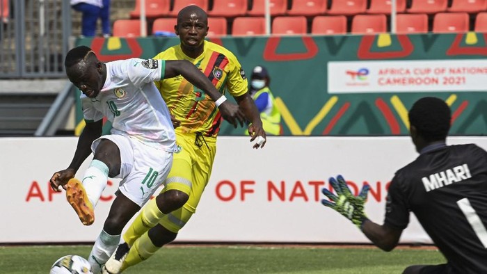 Senegals forward Sadio Mane (L) shoots and fails to score as Zimbabwes goalkeeper Petros Mhari (R) prepares to make a save during the Group B Africa Cup of Nations (CAN) 2021 football match between Senegal and Zimbabwe at Stade de Kouekong in Bafoussam on January 10, 2022. (Photo by Pius Utomi EKPEI / AFP)