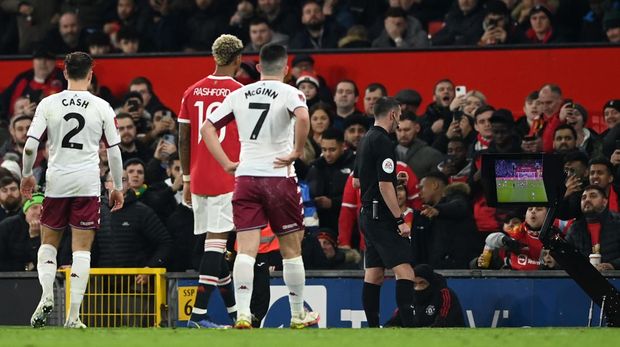 MANCHESTER, ENGLAND - JANUARY 10: Referee, Michael Oliver check the VAR during the Emirates FA Cup Third Round match between Manchester United and Aston Villa at Old Trafford on January 10, 2022 in Manchester, England. (Photo by Gareth Copley/Getty Images)