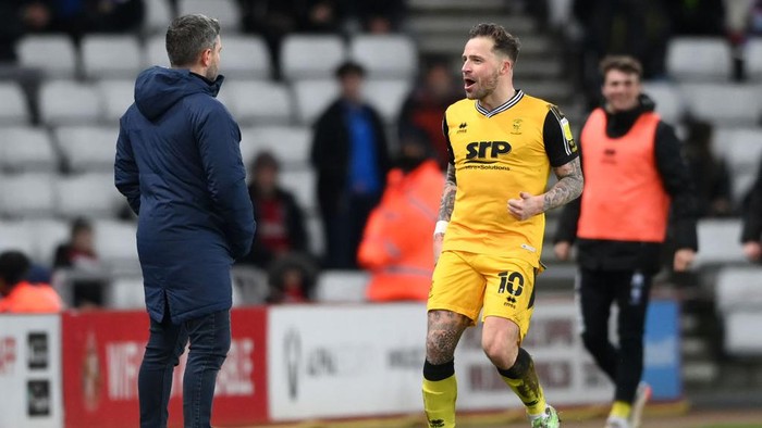 SUNDERLAND, ENGLAND - JANUARY 11: Lincoln player Chris Maguire (r) celebrates his opening goal in front of Sunderland manager Lee Johnson during the Sky Bet League One match between Sunderland and Lincoln City at Stadium of Light on January 11, 2022 in Sunderland, England. (Photo by Stu Forster/Getty Images)