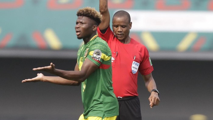 Referee Janny Sikazwe of Zambia, right, shows Malis El Bilal Toure a red card during the African Cup of Nations 2022 group F soccer match between Tunisia and Mali at the Limbe Omnisport Stadium in Limbe, Cameroon, Wednesday, Jan. 12, 2022. (AP Photo/Sunday Alammba)