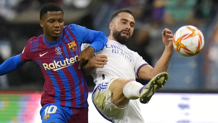 /ba/10/, left, and Real Madrids Dani Carvajalfight for the ball during the Spanish Super Cup semi final soccer match between Barcelona and Real Madrid at King Fahd stadium in Riyadh, Saudi Arabia, Wednesday, Jan. 12, 2022. (AP Photo/Hassan Ammar)