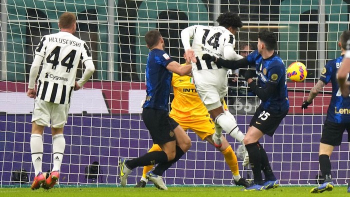 Juventus' Alvaro Morata, center, challenges for the ball with Inter Milan's Stefan de Vrij, right, and Inter Milan's Hakan Calhanoglu during the Italian Super Cup final soccer match between Inter Milan and Juventus at the San Siro Stadium, in Milan, Italy, Wednesday, Jan. 12, 2022. (AP Photo/Luca Bruno)