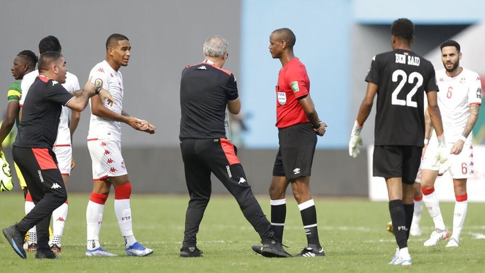 Tunisias head coach Mondher Kebaier, center left, gestures to the referee Janny Sikazwe of Zambia, during the African Cup of Nations 2022 group F soccer match between Tunisia and Mali at the Limbe Omnisport Stadium in Limbe, Cameroon, Wednesday, Jan. 12, 2022. (AP Photo/Sunday Alamba)
