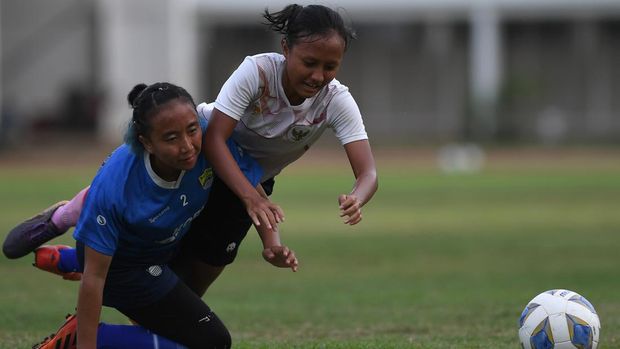 Pemain Timnas Putri Indonesia Viny Silfianus (kanan) dan pemain Akademi Persib Putri Daiva terjatuh saat berebut bola dalam pertandingan uji coba di Stadion Madya, kompleks Gelora Bung Karno (GBK), Jakarta, Kamis (13/1/2022). Uji coba tersebut dalam rangka persiapan Timnas Putri Indonesia menghadapi Piala Asia Putri 2022 di India pada 20 Januari hingga 6 Februari 2022. ANTARA FOTO/Sigid Kurniawan/hp.