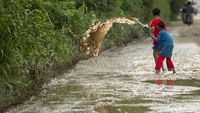 Aksi Anak-anak Kuras Air dari Jalan Berlubang di Kabupaten Bekasi