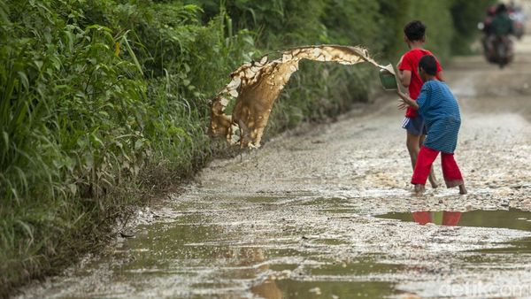 Aksi Anak-anak Kuras Air dari Jalan Berlubang di Kabupaten Bekasi