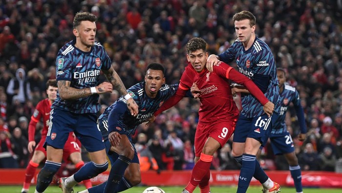LIVERPOOL, ENGLAND - JANUARY 13: Roberto Firmino of Liverpool is challenged by Rob Holding, Ben White and Gabriel of Arsenal during the Carabao Cup Semi Final First Leg match between Liverpool and Arsenal at Anfield on January 13, 2022 in Liverpool, England. (Photo by Michael Regan/Getty Images)