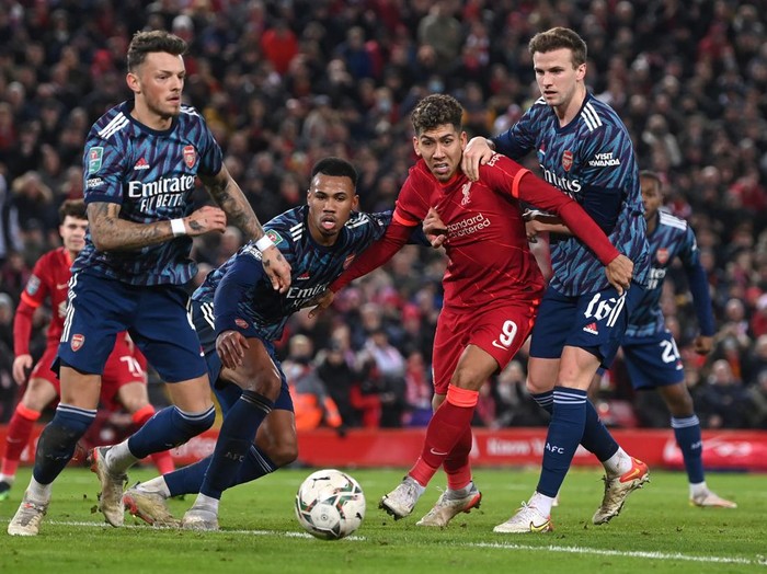 LIVERPOOL, ENGLAND - JANUARY 13: Roberto Firmino of Liverpool is challenged by Rob Holding, Ben White and Gabriel of Arsenal during the Carabao Cup Semi Final First Leg match between Liverpool and Arsenal at Anfield on January 13, 2022 in Liverpool, England. (Photo by Michael Regan/Getty Images)
