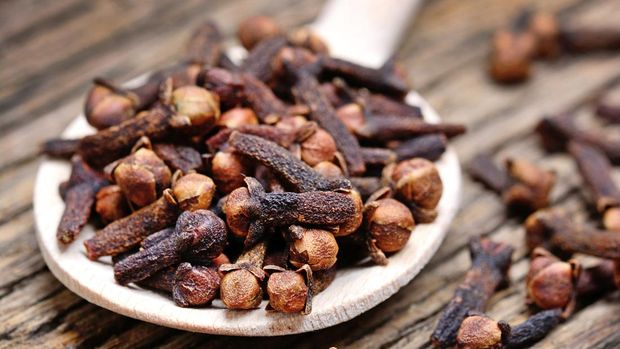 Close up of clove in a wooden spoon on old table