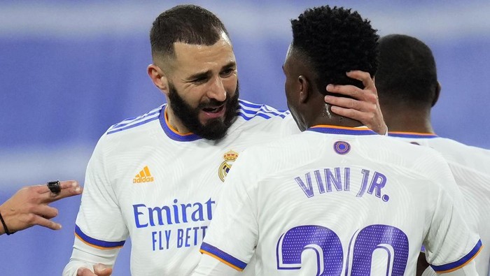 Real Madrids Karim Benzema celebrates with teammate Vinicius Junior, after scoring his sides first goal during the Spanish La Liga soccer match between Real Madrid and Sevilla at the Bernabeu stadium in Madrid, Spain, Sunday, Nov. 28, 2021. (AP Photo/Manu Fernandez)