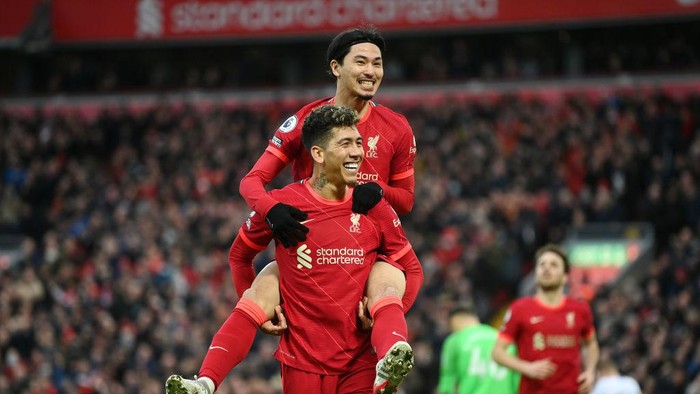 LIVERPOOL, ENGLAND - JANUARY 16: Takumi Minamino of Liverpool celebrates with Roberto Firmino after scoring their teams third goal during the Premier League match between Liverpool and Brentford at Anfield on January 16, 2022 in Liverpool, England. (Photo by Michael Regan/Getty Images)