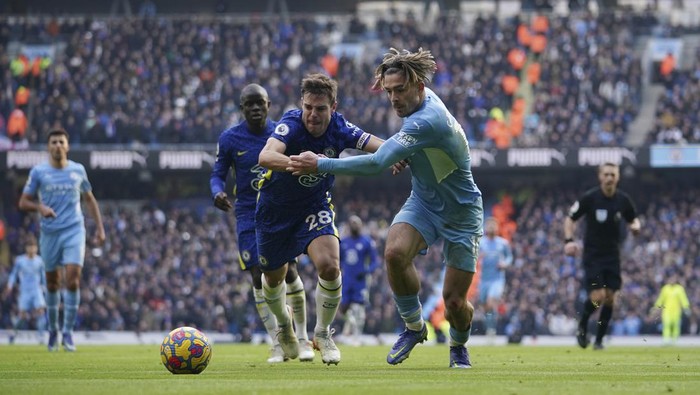 Manchester Citys Jack Grealish, centre right, challenges for the ball with Chelseas Cesar Azpilicueta during an English Premier League soccer match between Manchester City and Chelsea at the Etihad stadium in Manchester, England, Saturday, Jan. 15, 2022. (AP Photo/Dave Thompson)