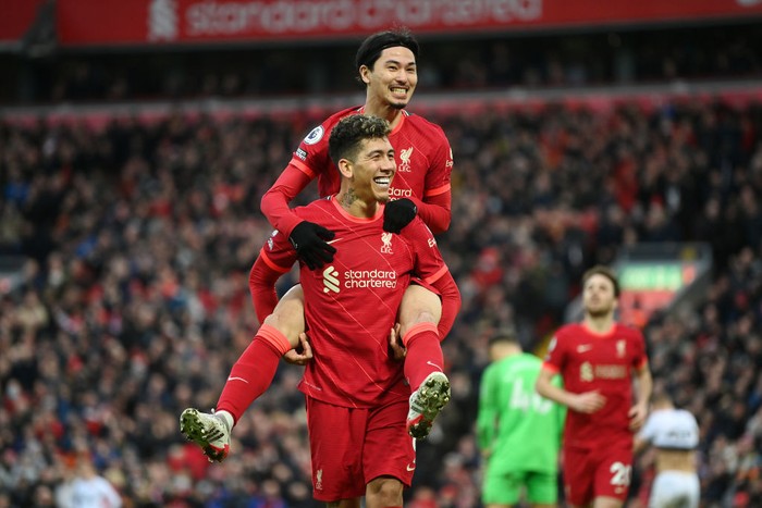 LIVERPOOL, ENGLAND - JANUARY 16: Takumi Minamino of Liverpool celebrates with Roberto Firmino after scoring their team's third goal during the Premier League match between Liverpool and Brentford at Anfield on January 16, 2022 in Liverpool, England. (Photo by Michael Regan/Getty Images)