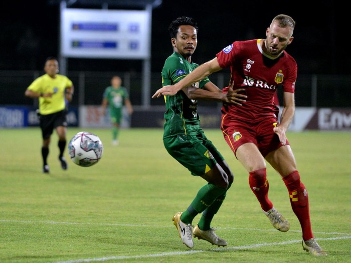 Pesepak bola Bhayangkara FC Melvin Platje (kanan) berebut bola dengan pesepak bola Persebaya Surabaya Muhammad Hidayat (kiri) saat pertandingan Liga 1 di Stadion I Gusti Ngurah Rai, Denpasar, Bali, Selasa (18/1/2022). ANTARA FOTO/Fikri Yusuf/hp.