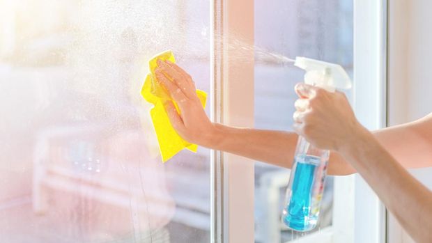 Hands with napkin cleaning window. Washing the glass on the windows with cleaning spray. Selective soft focus. Empty place for text, copy space. Window cleaning home.
