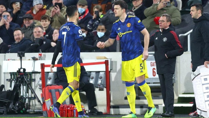 cristiano ronaldo harry maguire manchester united liga inggris premier league BRENTFORD, ENGLAND - JANUARY 19: Harry Maguire of Manchester United replaces teammate Cristiano Ronaldo during the Premier League match between Brentford and Manchester United at Brentford Community Stadium on January 19, 2022 in Brentford, England. (Photo by Clive Rose/Getty Images)