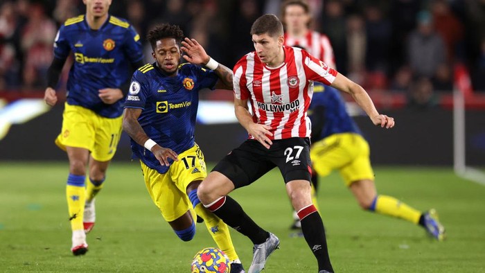 BRENTFORD, ENGLAND - JANUARY 19: Vitaly Janelt of Brentford on the ball whilst under pressure from Fred of Manchester United during the Premier League match between Brentford and Manchester United at Brentford Community Stadium on January 19, 2022 in Brentford, England. (Photo by Alex Pantling/Getty Images)