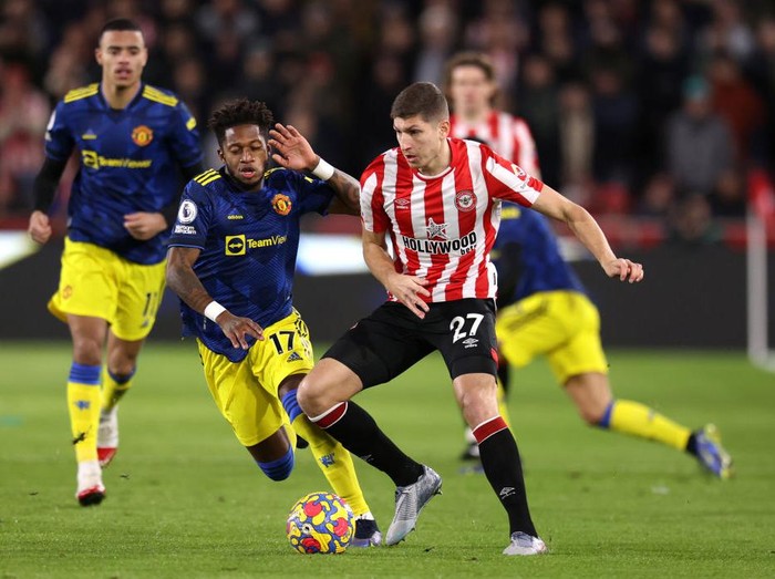 BRENTFORD, ENGLAND - JANUARY 19: Vitaly Janelt of Brentford on the ball whilst under pressure from Fred of Manchester United during the Premier League match between Brentford and Manchester United at Brentford Community Stadium on January 19, 2022 in Brentford, England. (Photo by Alex Pantling/Getty Images)