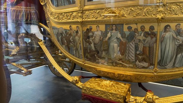The controversial painting on the Golden Carriage is seen as the carriage is displayed at the Amsterdam Museum in Amsterdam, Wednesday Jan. 19, 2022. The Dutch king ruled out Thursday, Jan. 13, 2022, using in the near future the royal family's Golden Carriage, one side of which is decorated with a painting that has drawn fire from critics who say it glorifies the Netherlands' colonial past, including its role in the global slave trade. (AP Photo/Peter Dejong)