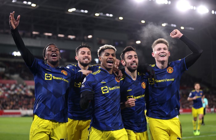 Manchester United BRENTFORD, ENGLAND - JANUARY 19: Marcus Rashford of Manchester United celebrates with teammates Anthony Elanga, Alex Telles, Bruno Fernandes and Scott McTominay after scoring their side's third goal during the Premier League match between Brentford and Manchester United at Brentford Community Stadium on January 19, 2022 in Brentford, England. (Photo by Alex Pantling/Getty Images)