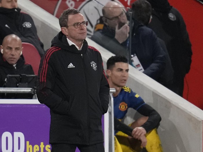 Manchester United's Cristiano Ronaldo sits watching the game behind Manchester United's interim manager Ralf Rangnick after being substituted during an English Premier League soccer match between Brentford and Manchester United at the Brentford Community Stadium in London, Wednesday, Jan. 19, 2022. (AP Photo/Matt Dunham)