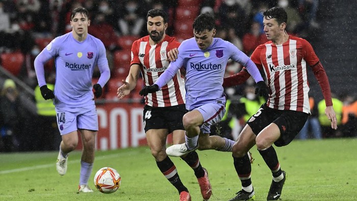 Barcelonas Pedri, center, is challenged by Athletic Bilbaos Mikel Vesga, right and Athletic Bilbaos Inigo Martinez during the Spanish Copa del Rey Cup round of 16 soccer match between Athletic Club and Barcelona at the San Mames stadium in Bilbao, Friday, Jan. 21, 2022. (AP Photo/Alvaro Barrientos)