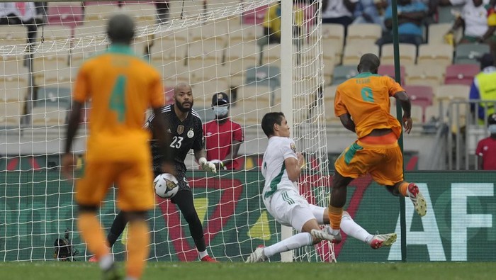 Ivory Coasts Franck Kessie, right, scores a goal as Algerias Youcef Atal looks on during the African Cup of Nations 2022 group E soccer match between Ivory Coast and Algeria at the Japoma Stadium in Douala, Cameroon, Thursday, Jan. 20, 2022. (AP Photo/Themba Hadebe)