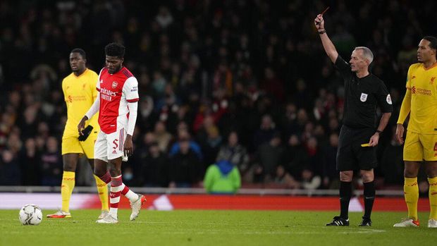 Referee Martin Atkinson shows the red card to Arsenal's Thomas Partey during the English League Cup semifinal second leg soccer match between Arsenal and Liverpool at the Emirates Stadium in London, Thursday, Jan. 20, 2022. (AP Photo/Matt Dunham)