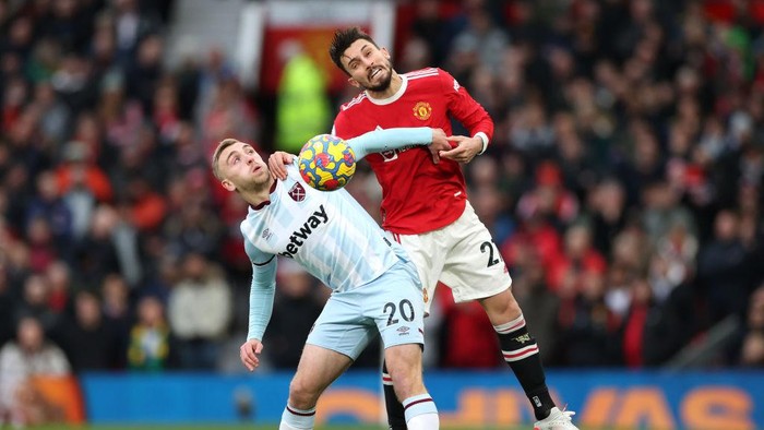 MANCHESTER, ENGLAND - JANUARY 22: Jarrod Bowen of West Ham United is challenged by Alex Telles of Manchester United during the Premier League match between Manchester United and West Ham United at Old Trafford on January 22, 2022 in Manchester, England. (Photo by Naomi Baker/Getty Images)