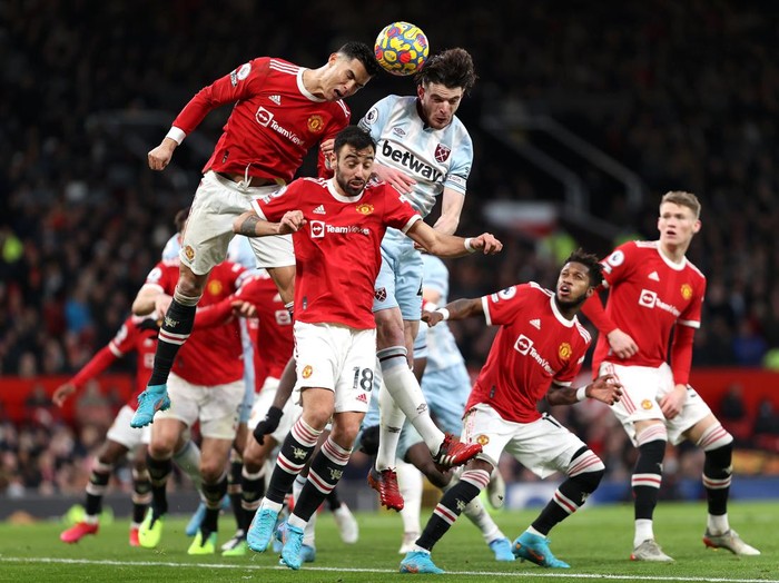 MANCHESTER, ENGLAND - JANUARY 22: Cristiano Ronaldo of Manchester United jumps for the ball with Declan Rice of West Ham United during the Premier League match between Manchester United and West Ham United at Old Trafford on January 22, 2022 in Manchester, England. (Photo by Naomi Baker/Getty Images)