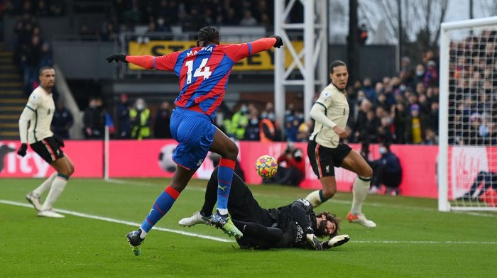 LONDON, ENGLAND - JANUARY 23: Jean-Philippe Mateta of Crystal Palace shoots past Alisson Becker of Liverpool during the Premier League match between Crystal Palace  and  Liverpool at Selhurst Park on January 23, 2022 in London, England. (Photo by Mike Hewitt/Getty Images)