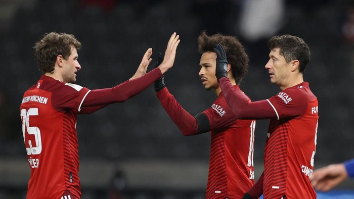 BERLIN, GERMANY - JANUARY 23: Leroy Sané of Muenchen celebrates scoring his teams third gaol with Thomas Mueller and Robert Lewandowski during the Bundesliga match between Hertha BSC and FC Bayern München at Olympiastadion on January 23, 2022 in Berlin, Germany. (Photo by Maja Hitij/Getty Images)