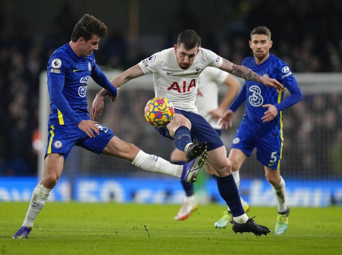 Chelsea's Hakim Ziyech, right, jumps for the ball with Tottenham's Ben Davies during the English Premier League soccer match between Chelsea and Tottenham Hotspur at Stamford Bridge stadium in London, England, Sunday, Jan. 23, 2022. (AP Photo/Kirsty Wigglesworth)