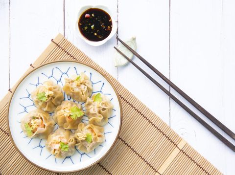 Traditional chinese steamed dumplings Dim Sums with sauce and chopsticks on light surface with copy space. Flat lay composition Asian food background.