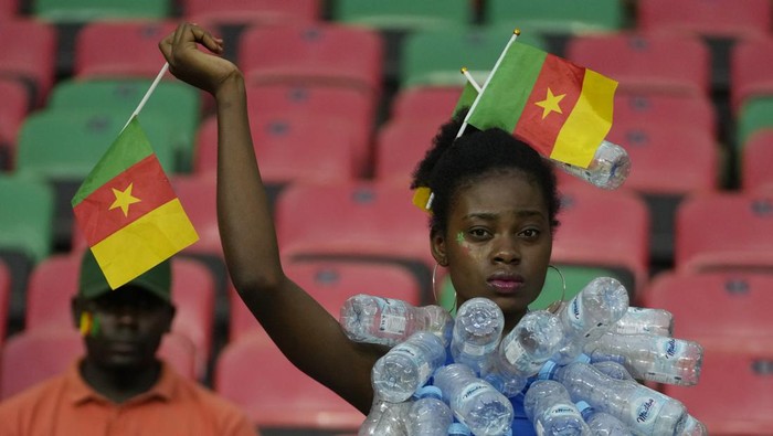 A Cameroons supporter wearing a top covered with recycle plastic bottles waits for the start of the African Cup of Nations 2022 round of 16 soccer match between Cameroon and Comoros at the Olembe stadium in Yaounde, Cameroon, Monday, Jan. 24, 2022. (AP Photo/Themba Hadebe)