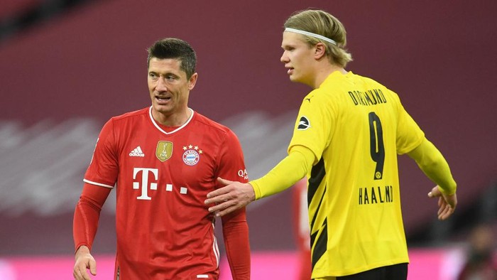 Bayern Munichs Polish forward Robert Lewandowski (L) and Dortmunds Norwegian forward Erling Braut Haaland gesture during the German first division Bundesliga football match between FC Bayern Munich and BVB Borussia Dortmund in Munich, southern Germany, on March 6, 2021. (Photo by ANDREAS GEBERT / POOL / AFP) / DFL REGULATIONS PROHIBIT ANY USE OF PHOTOGRAPHS AS IMAGE SEQUENCES AND/OR QUASI-VIDEO