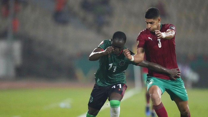 Malawis Gabadinho Mhango, left, is challenged by Moroccos Adam Masina during the African Cup of Nations 2022 round of 16 soccer match between Morocco and Malawi at the Ahmadou Ahidjo stadium in Yaounde, Cameroon, Tuesday, Jan. 25, 2022. (AP Photo/Themba Hadebe)